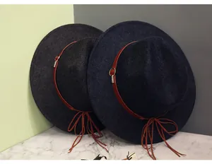 Detail view of charcoal and navy wool fedora hats with leather bands and metal buckles