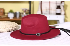 Close-up of deep red wool fedora featuring a black leather band with vintage silver buckles
