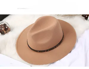 Close-up of khaki wool fedora hat with black leather strap and gold metal rivets