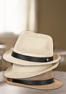 Close-up of woven straw jazz hats with leather bands and metallic buckle details