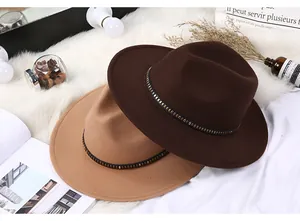 Detail of khaki and brown fedora hats with rivet leather bands on a white fur rug