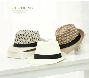 Close-up of three woven straw fedora hats with stylish black grosgrain ribbons on a desk