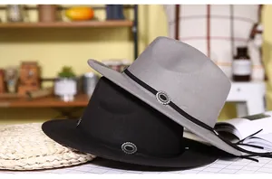 Detail of wide brim fedora hats in black and gray with vintage engraved metal buckles