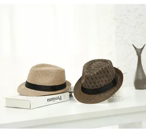 Detail of straw fedora hats with black ribbons in plain beige and geometric patterns
