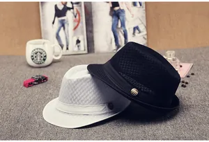 Close-up of mesh texture and golden metal emblem on black and white fedora hats