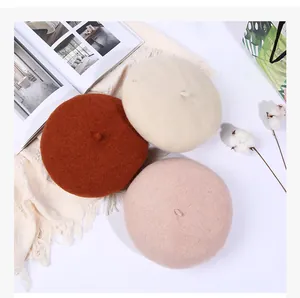 Flachbildansicht von Wollbaskenmützen in Karamell, Beige und Rosa im gemütlichen Winterstil