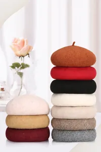 Stapel Wollbaskenmützen in verschiedenen Farben wie Rot, Beige und Grautönen