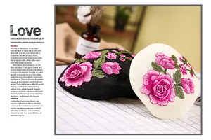 Detail der bestickten rosa Rosen auf eleganten schwarz-weißen Netz-Baskenmützen