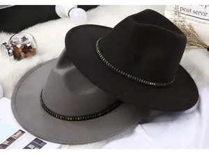 Detail of wool fedora hats with metal rivet leather belts on a soft plush background
