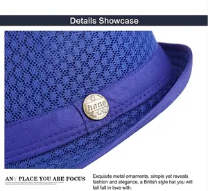 Macro detail of navy mesh fedora hat featuring a vintage bronze logo badge and ribbon