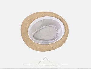 Detailed interior of a straw fedora hat with a white sweatband and grey fabric lining