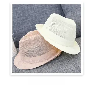Detail of cream and pink woven straw fedora hats with textured ribbon bands