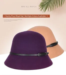 Close-up of wool cloche hats in purple and camel with leather belts and metal buckles