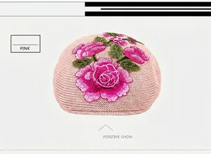 Detailed close-up of pink knitted beret featuring exquisite rose flower embroidery