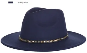 Detail of navy blue felt fedora hat featuring a black band with metallic rivets