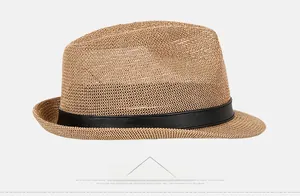 Side view detail of a khaki straw jazz hat with black decorative leather band and woven texture