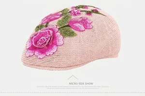 Close-up of pink knit mesh beret with detailed rose flower embroidery for women