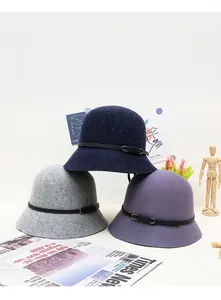 Three wool cloche hats in navy, gray, and purple with thin black leather belts