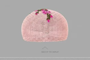 Rear view of pink knitted beret featuring delicate floral embroidery and breathable texture
