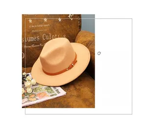 Detail of camel wool fedora with wide brim and leather belt on vintage sofa