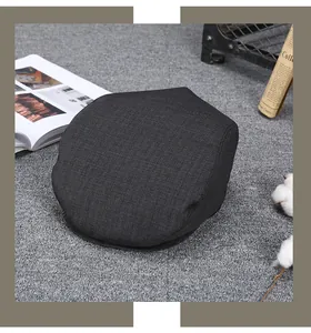 Close-up of vintage dark grey flat cap with textured fabric on a retro background