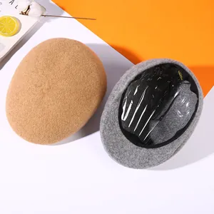 Thick wool felt newsboy caps in camel and gray displayed with autumn lifestyle props