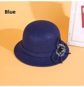 Détail d'un chapeau cloche bleu en feutre avec nœud ruban et pompon en peluche