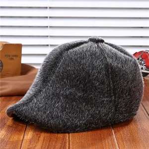 Classic grey faux fur newsboy cap for men with soft texture on a wooden background