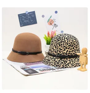 Close-up of wool bucket hats in camel and leopard print with black decorative belts