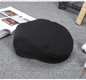 Detailed view of the black wool texture and brim of this vintage men's newsboy cap