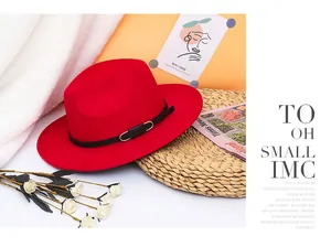 Detail of red wool felt fedora featuring a black band with silver metal buckle