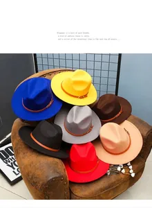 Collection of colorful felt fedora hats with leather bands on a vintage leather chair