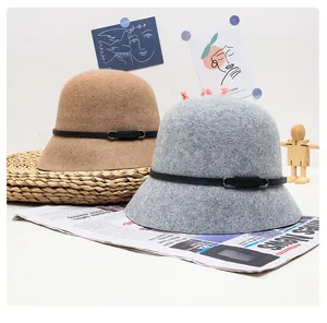 Detail of wool cloche hats in camel and grey with elegant leather decorative bands
