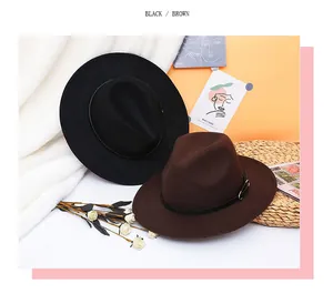Detail of wool fedora hats in black and brown with buckle belts on white faux fur