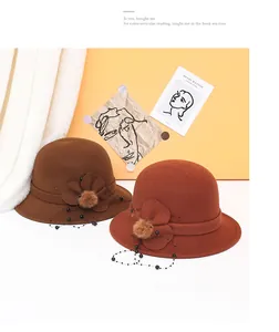 Dettaglio di cappelli cloche in lana con fiori, pompon e rete con perline applicate