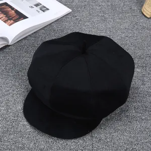Classic black wool newsboy cap for men featuring premium thick fabric on grey background