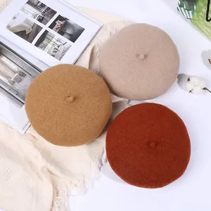 Klassische Wollbaskenmützen in Kamel, Beige und Karamell auf gemütlichem Lifestyle-Hintergrund
