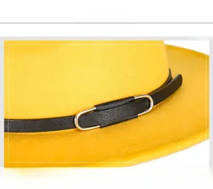 Detail view of yellow wool felt fedora featuring a black leather band and silver metal buckle