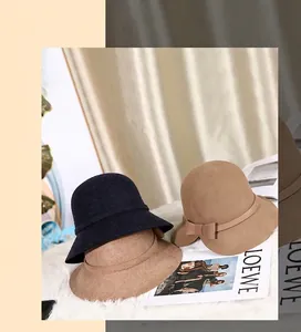 Detailed texture of wool cloche hats in camel and black with delicate bow decoration
