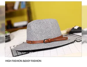 Detail of grey wool fedora hat featuring a brown leather band with metal buckle and rivets