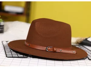 Detail of dark brown fedora hat featuring wool texture and leather belt with silver studs