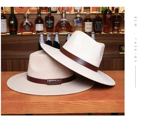 Detail of beige wool fedora hats featuring a leather band with LHASA engraving on a bar counter