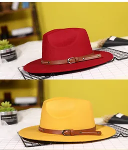 Detail of wool fedora hat with brown leather buckle strap in red and yellow colors