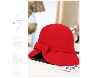 Close-up of red wool cloche hat featuring an elegant bow and asymmetrical wavy brim
