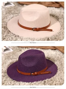 Detail of wide brim fedora hats in beige and purple with buckled leather bands