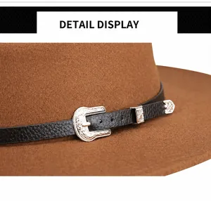 Detail of vintage silver buckle and black leather band on brown wool fedora hat
