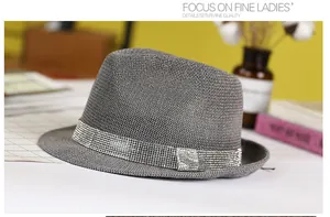 Detail of grey woven fedora hat featuring a wide rhinestone band and square crystal buckle