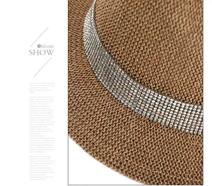 Detail of woven straw hat featuring multi-row rhinestone band and intricate braid texture