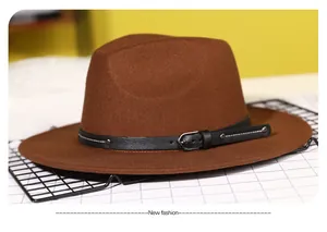 Detailed macro of brown wool fedora hat featuring black leather band and silver buckle