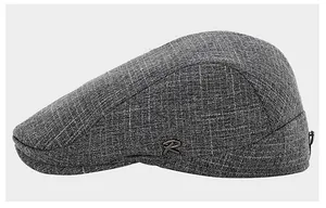 Détail de la casquette plate en coton gris montrant le tissu et le logo métal R